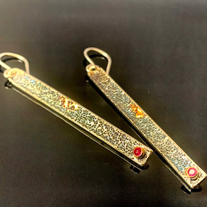 Solid sterling silver and gold earrings set with deep pink Rubies.